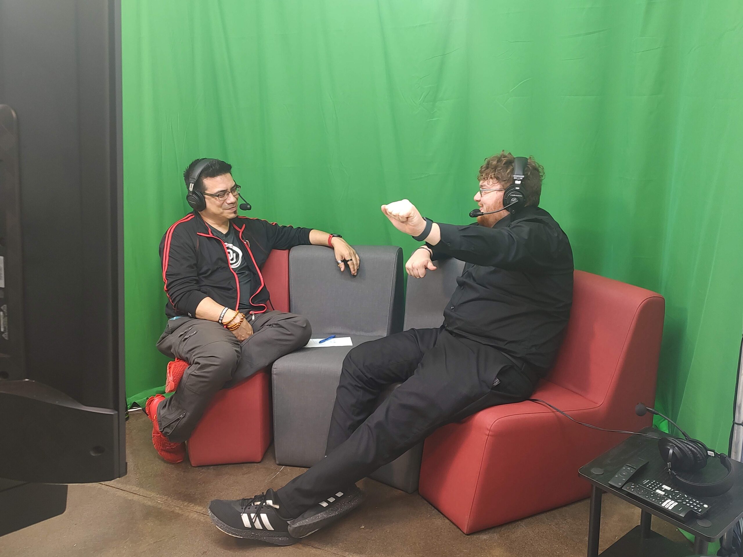 Director Mike Aguilar and Production Lead Joshua Watson talk in Gaming Lounge podcast room.