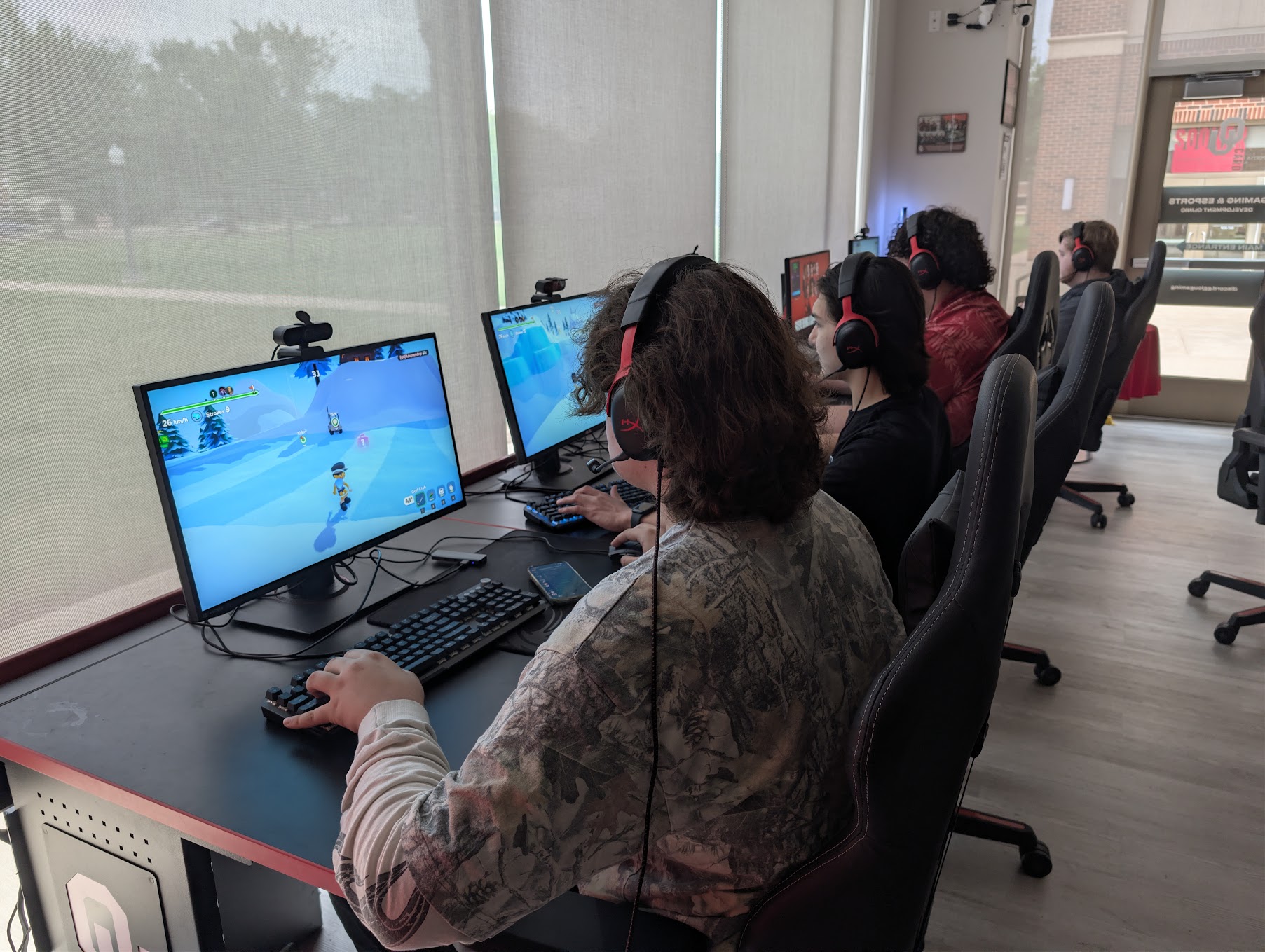 Three OU Esports gamers play video games on computers in the Developmental Clinic.